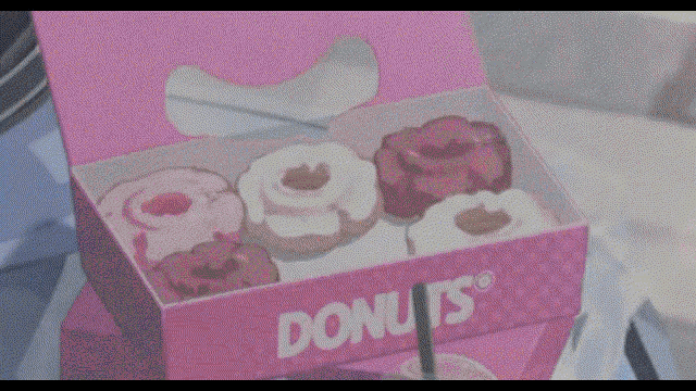 a box of donuts sits on a table next to a drink