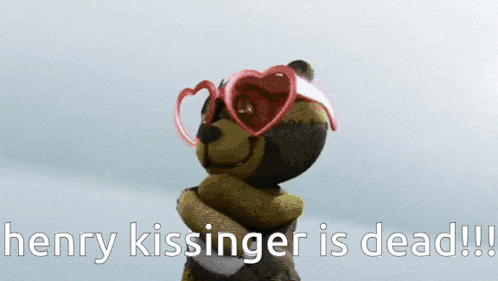 a teddy bear wearing heart shaped glasses with the words henry kissinger is dead written below it