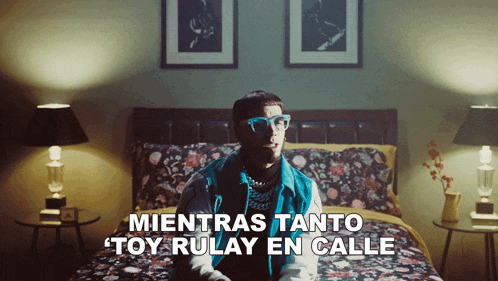 a man sitting on a bed with the words mientras tanto toy rulay en calle written below him