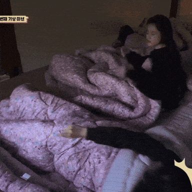 a woman laying on a bed with a purple blanket and a sign that says ' korean '