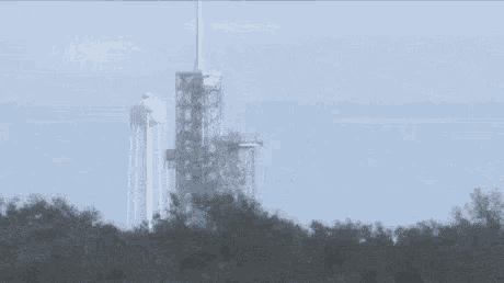 a rocket is being launched into space from a very tall tower .