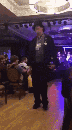 a man with a name tag on his neck stands in a room