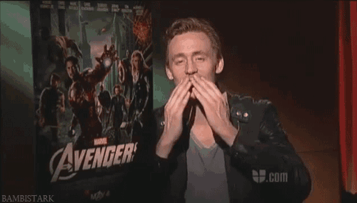 a man blowing a kiss in front of a poster for the avengers