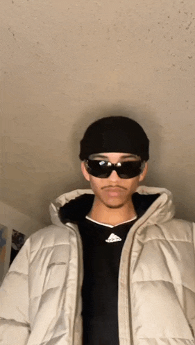 a man wearing sunglasses and a black beanie