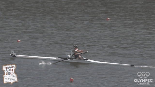 a person in a rowing boat with the olympic channel in the background