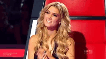 a woman with long blonde hair is sitting in a red chair .