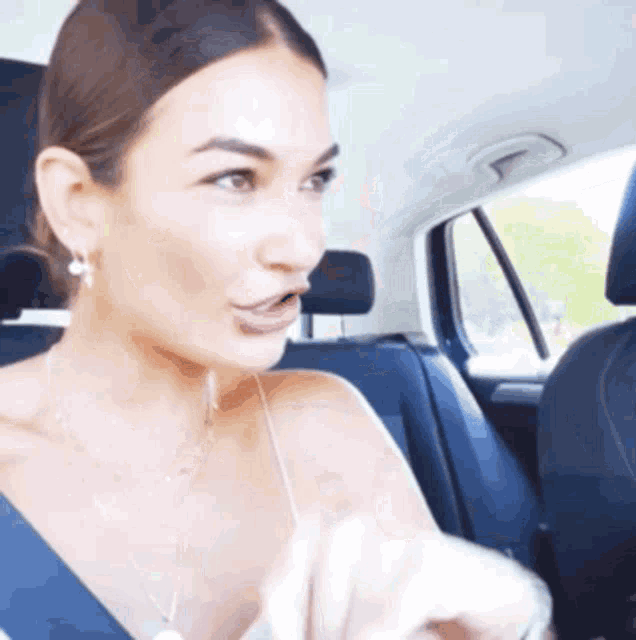 a woman in a car with her mouth open