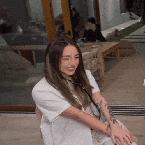 a woman with a tattoo on her arm is smiling
