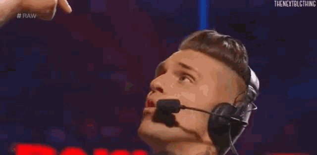 a man in a suit and tie is wearing a headset and talking into it .