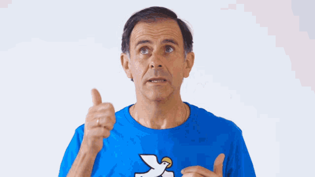 a man wearing a blue shirt with a bird on it giving a thumbs up