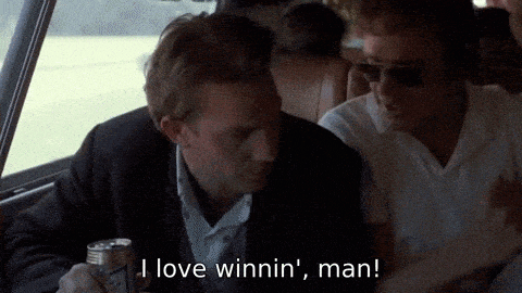 two men are sitting in a car and one of them is holding a can of beer and saying i love winnin ' man