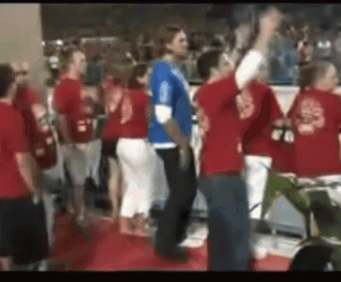a group of people wearing red shirts with the number 20 on the back are standing in a room