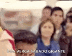 a group of people are standing next to each other in a room and talking .