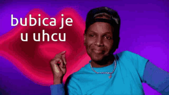 a man in a blue shirt is smiling in front of a red heart with the words bubica je u uhcu written on it