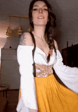 a woman wearing a yellow dress and a white shirt is dancing