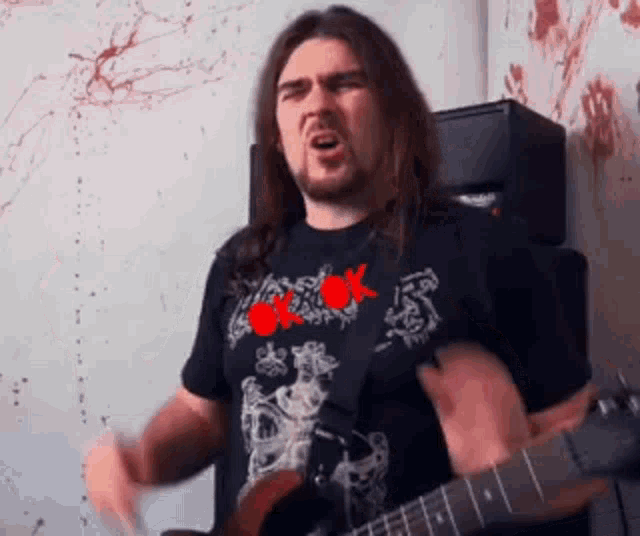 a man with long hair is playing a guitar and singing
