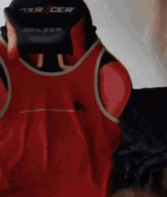 a red and black dxr racer gaming chair is sitting on a bed
