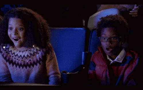a boy and a girl are watching a movie and one of them is saying woah awesome