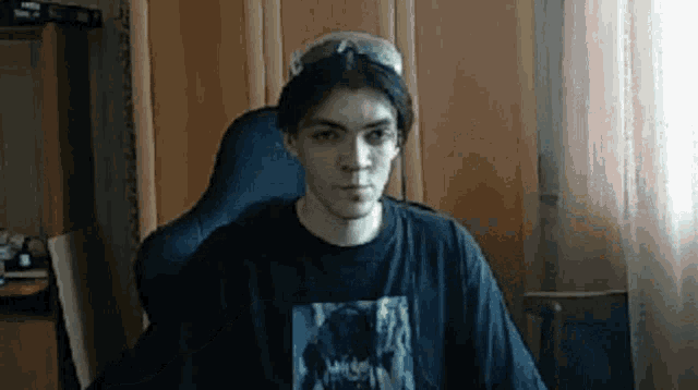 a young man wearing sunglasses is sitting in a chair .