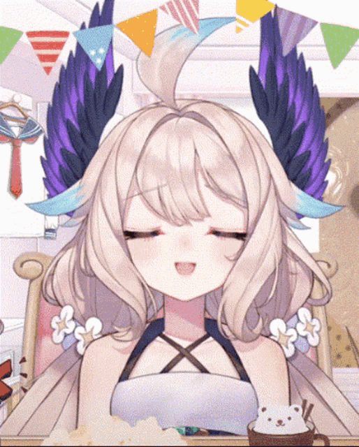 a girl with wings on her head is sitting at a table with her eyes closed .