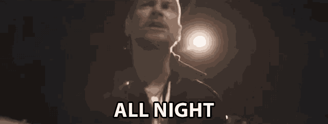 a man is standing in front of a street light and singing .