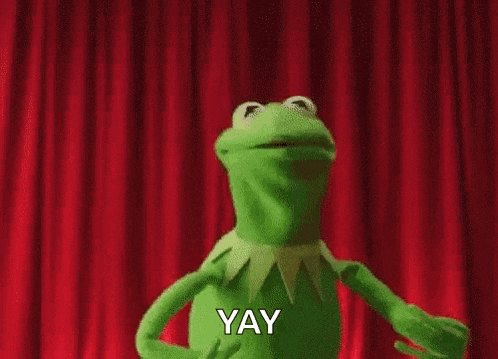 kermit the frog is dancing on stage in front of a red curtain and saying yay .
