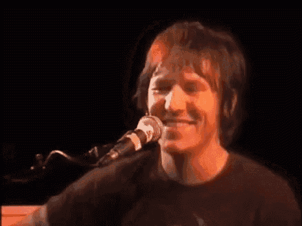 a man is singing into a microphone on stage .