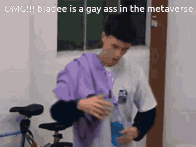 a man in a purple shirt is standing next to a bicycle and drinking from a bottle ..