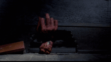 a person 's hand is sticking out of a hole in a wall and giving the middle finger