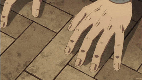a close up of a person 's hands on a brick floor