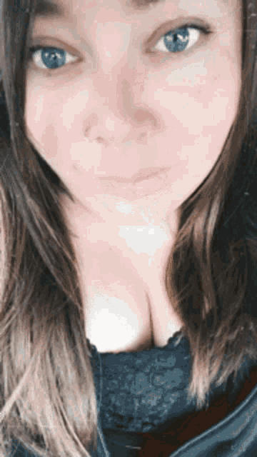 a woman with blue eyes and a nose ring looks at the camera