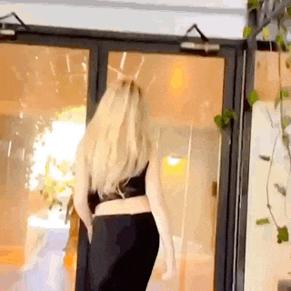 a woman is standing in front of a glass door in a room .