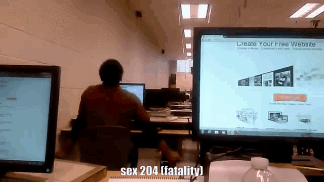 a man sits at a desk in front of a computer screen which says create your free website