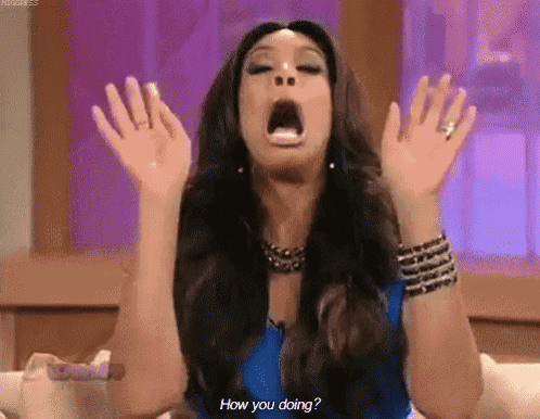 a woman is sitting on a couch with her mouth open and her hands up .