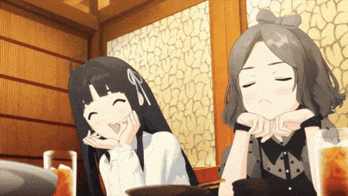 two anime girls are sitting next to each other and one is smiling