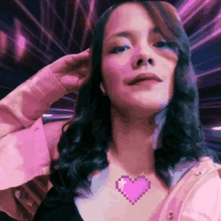 a woman wearing a necklace with a pixelated heart on it