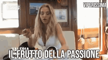 a woman in a white dress is sitting on a couch with the words il frutto della passione written above her