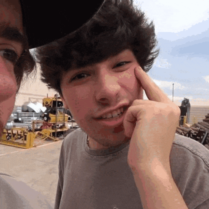 a young man is touching his face with his finger