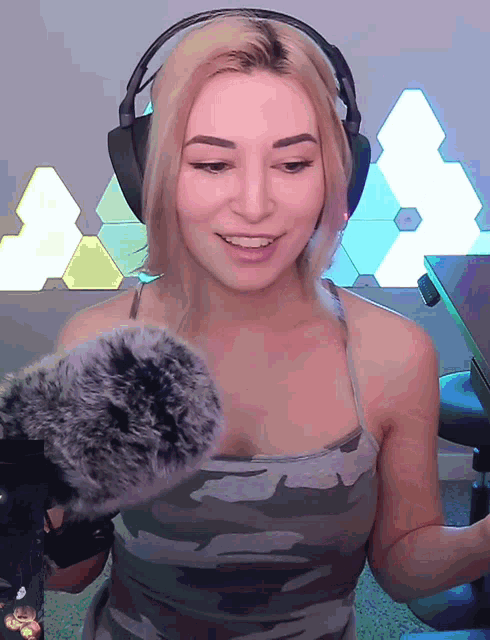 a woman wearing headphones holds a microphone in front of her