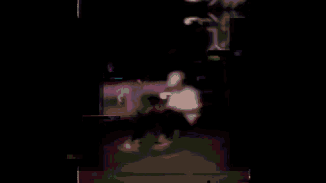 a blurry image of a person in a dark room with the letter m visible in the corner