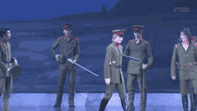 a group of men in military uniforms are standing on a stage in front of a sign that says " sky stage "