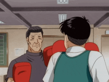 a man wearing red boxing gloves stands next to another man
