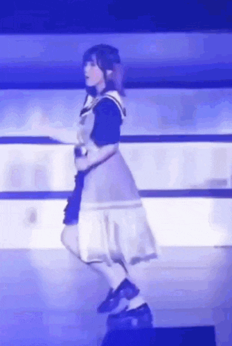 a woman in a dress is dancing on a stage with a microphone in her hand .