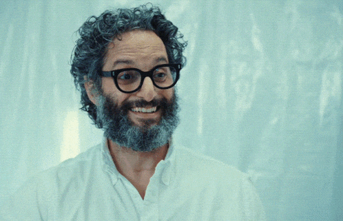 a man with glasses and a beard is pointing at something with the words i crushed it behind him