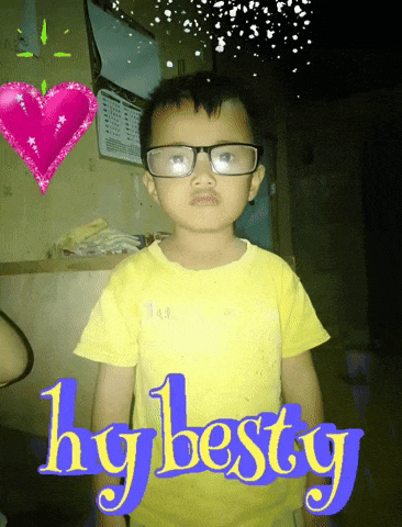 a young boy wearing glasses and a yellow shirt with the words hg besty written on it