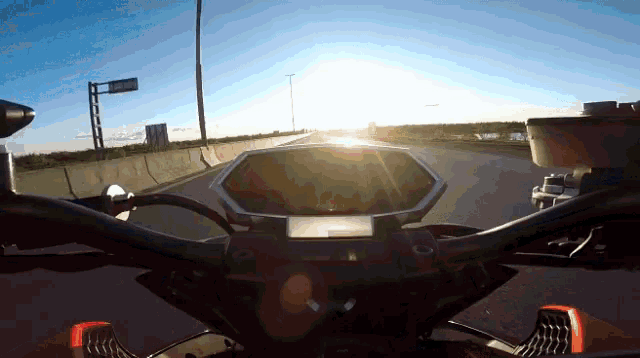 a motorcycle is driving down a highway at sunset