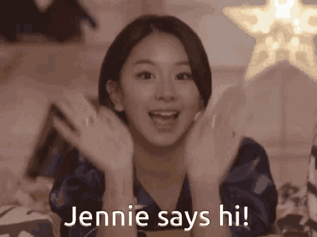 a woman is waving her hands and says jennie says hi