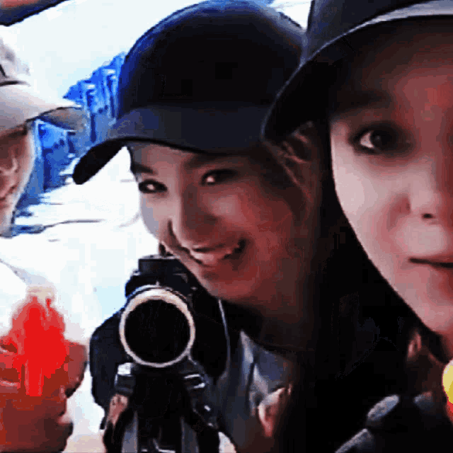 a woman wearing a hat is holding a camera