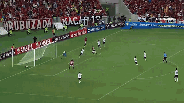 a soccer field with advertisements for qatar airways and amstel on the sidelines