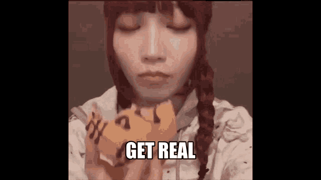 a girl with braids is eating a piece of cake with the words `` get real '' written on it .